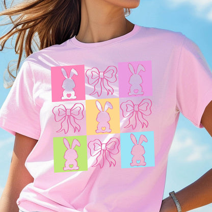 May include: Pink t-shirt with a colorful design of nine bunnies with bows. Each bunny is in a different colored square.