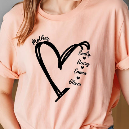 May include: A pink t-shirt with a black hand-drawn heart and the word "Mother" above it. Inside the heart are the names "Emily", "Henry", "Emma", and "Oliver" with a small heart symbol next to each name.