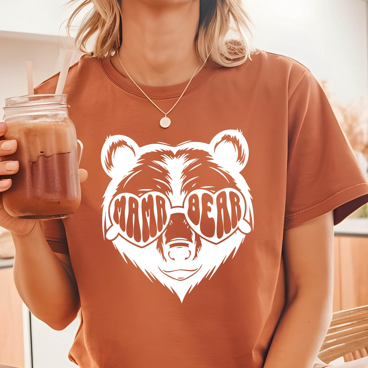 May include: A brown t-shirt with a white bear wearing heart-shaped sunglasses that say "Mama Bear".