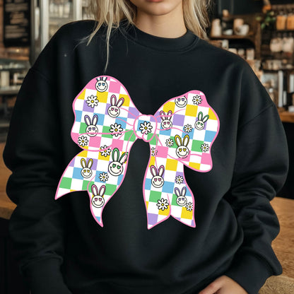 May include: Black sweatshirt with a large pink bow printed on the front. The bow is made up of a checkered pattern with bunny faces and flowers.