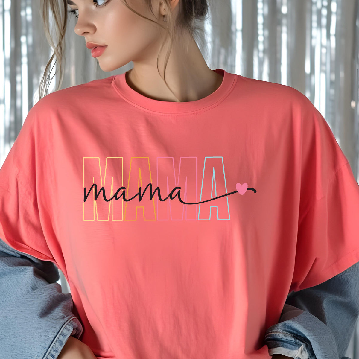 May include: A coral pink t-shirt with the word "mama" in rainbow colors and a small pink heart.