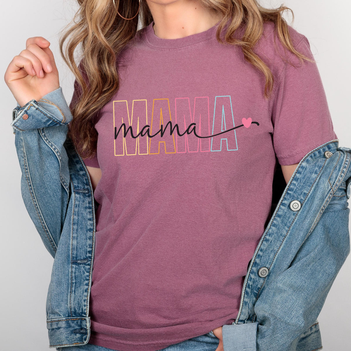 May include: A mauve colored t-shirt with the word "mama" in rainbow colors with a small pink heart.