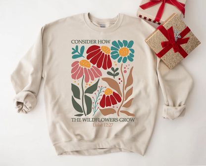 May include: Beige sweatshirt with a floral design and the text "Consider how the wildflowers grow Luke 12:27".