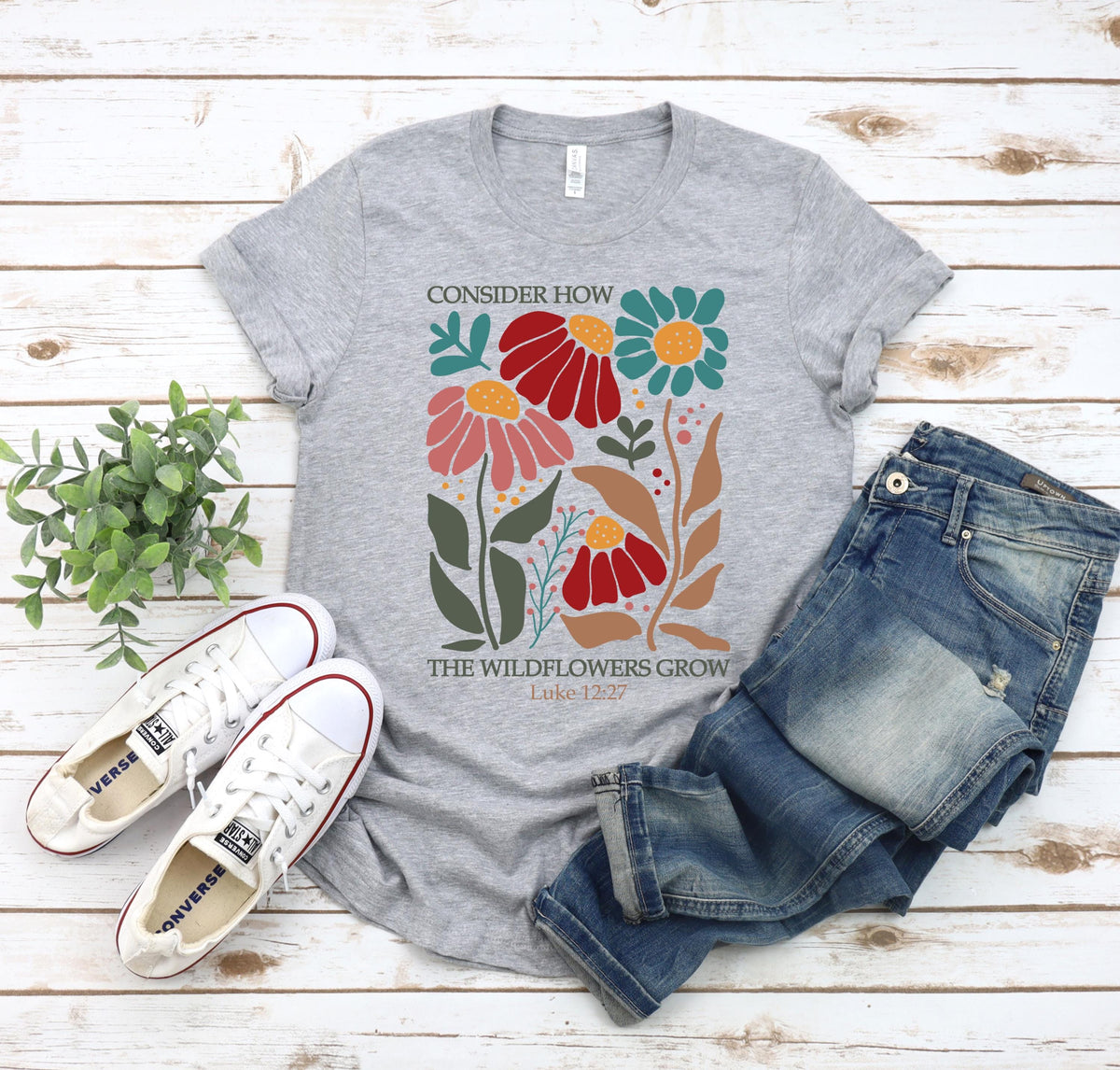May include: Gray t-shirt with a floral design and the text "Consider how the wildflowers grow Luke 12:27".
