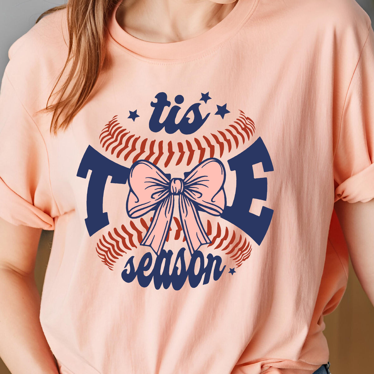 May include: Pink t-shirt with a baseball graphic and the text "tis the season" in navy blue.