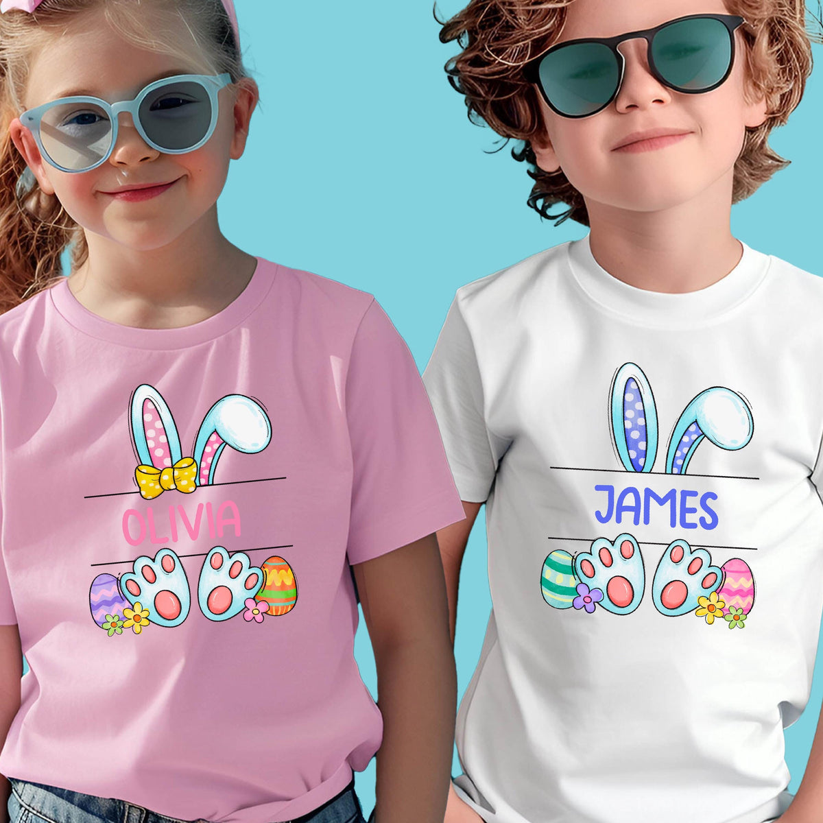May include: Two children's t-shirts with Easter bunny ears and paw prints. The pink shirt has the name "Olivia" on it and the white shirt has the name "JAMES" on it.