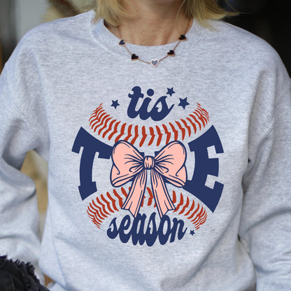 May include: Gray sweatshirt with a baseball graphic and the text "tis the season" in navy blue. A pink bow is in the center of the baseball graphic.