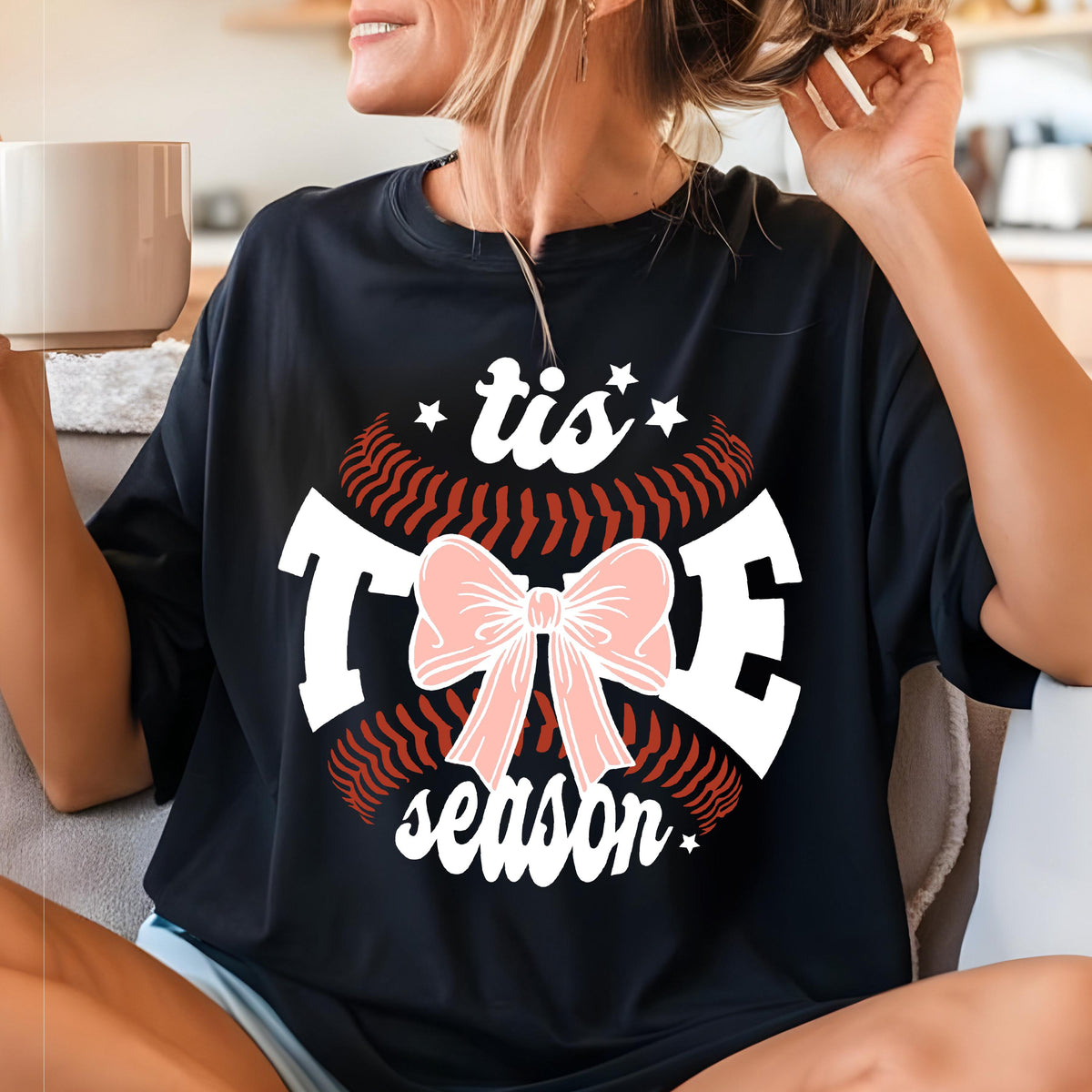 May include: Black t-shirt with a white baseball graphic and the text "tis the season" with a pink bow.