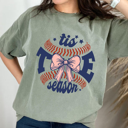 May include: Green t-shirt with a baseball graphic and the text "tis the season" with a pink bow in the center.