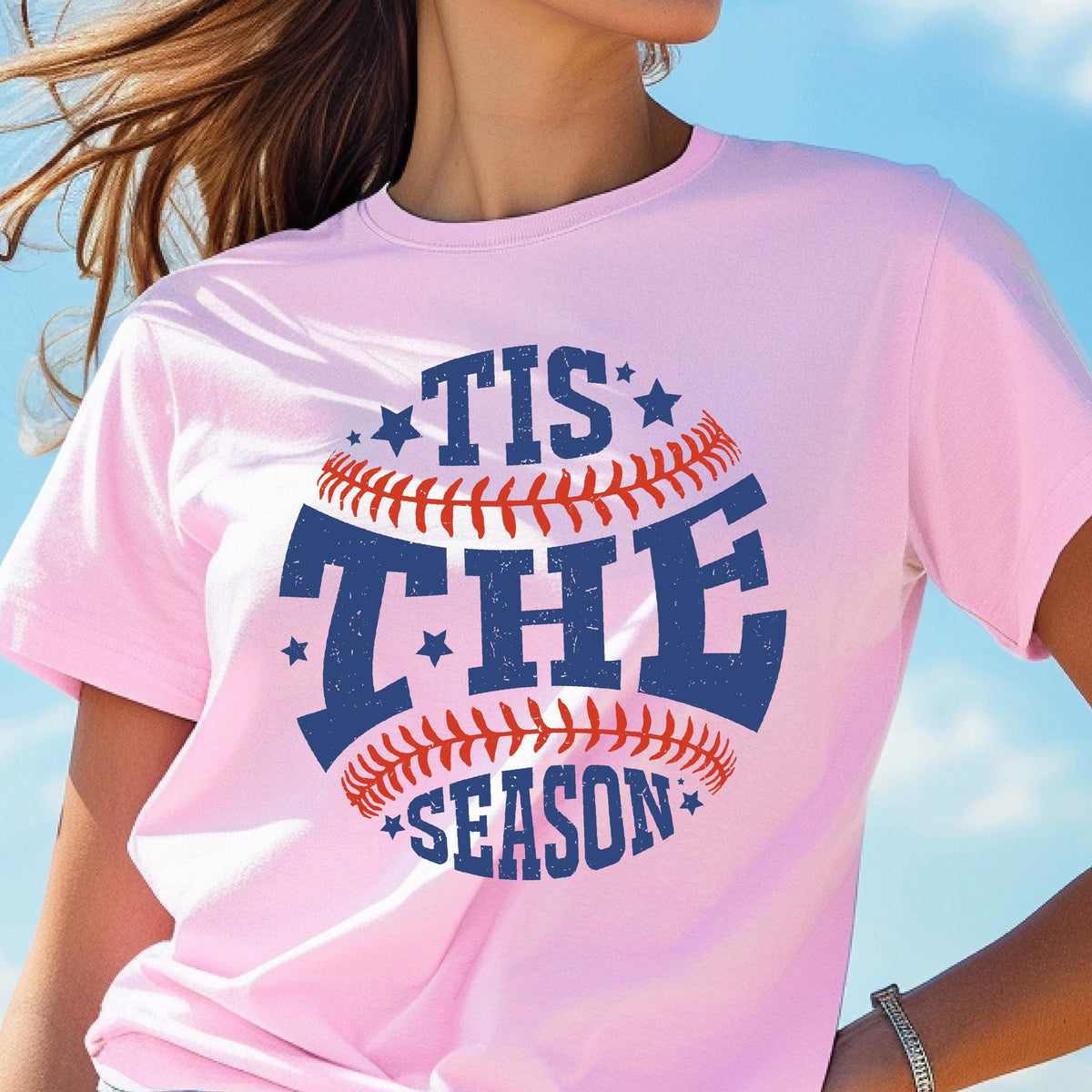 May include: Pink t-shirt with a baseball graphic and the text "Tis the Season" in blue and red.