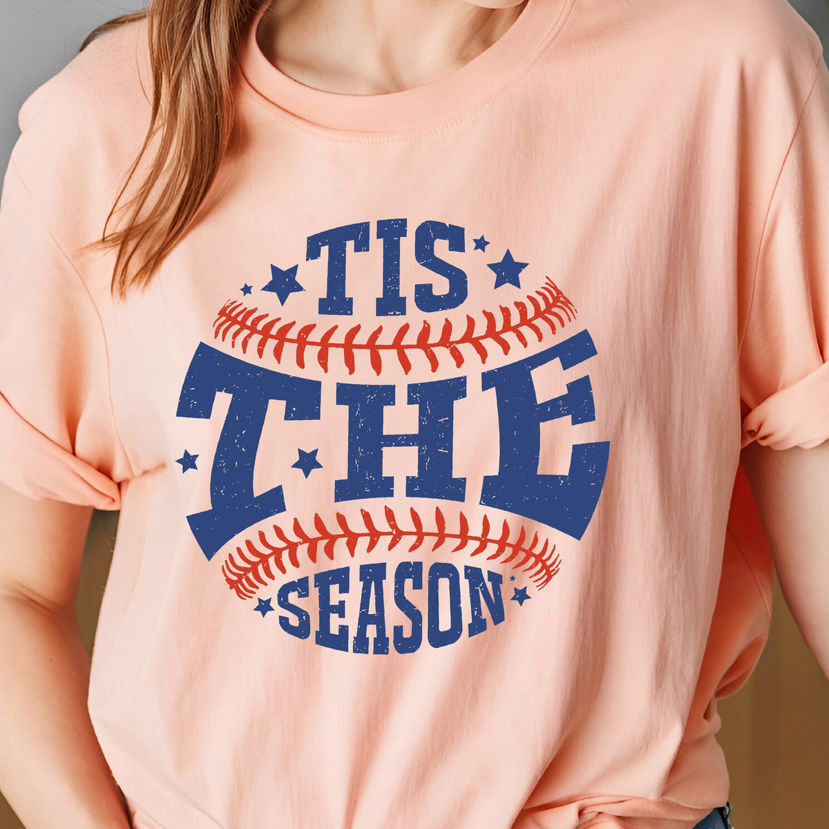 May include: A pink t-shirt with a baseball graphic and the text "Tis the Season" in blue and red.
