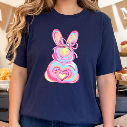 May include: A navy blue t-shirt with a pink, blue, and yellow swirl design of a bunny with a heart and a bow.