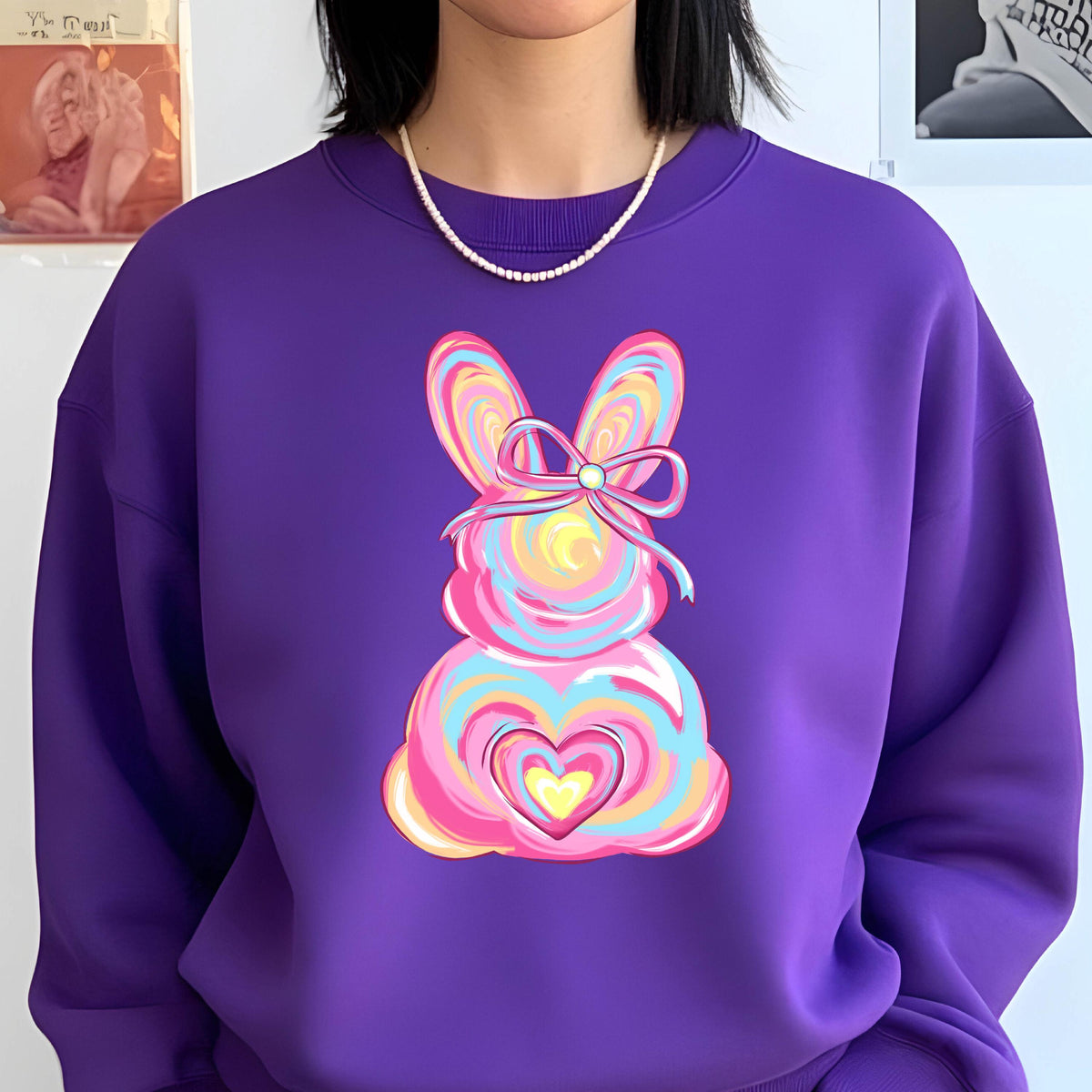 May include: Purple sweatshirt with a colorful swirl design of a bunny with a bow and a heart. 