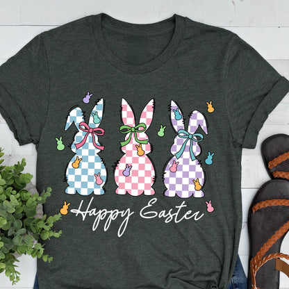 May include: A green t-shirt with three checkered Easter bunnies in blue, pink, and purple. The bunnies have bows and are surrounded by pastel-colored jelly beans. The text "Happy Easter" is printed below the bunnies.