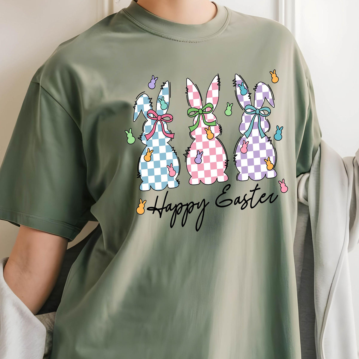 May include: A green t-shirt with a graphic of three checkered Easter bunnies and the text "Happy Easter".