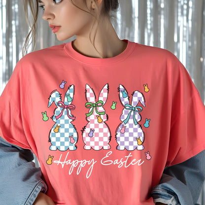 May include: A coral pink t-shirt with a graphic of three checkered Easter bunnies and the text "Happy Easter".