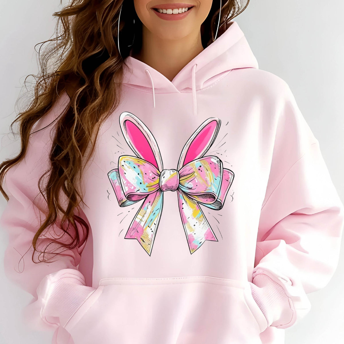 May include: Pink hoodie with a colorful bow and bunny ears graphic print.