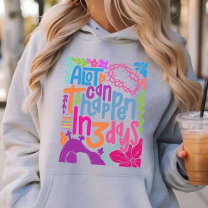 May include: A gray hoodie with a colorful graphic design that says "A lot can happen in 3 days". The graphic includes a cross, a crown of thorns, an Easter egg, and a tomb.