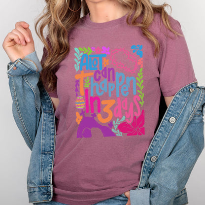 May include: A purple t-shirt with a colorful graphic design that says "A lot can happen in 3 days". The graphic includes flowers, leaves, and an Easter egg.