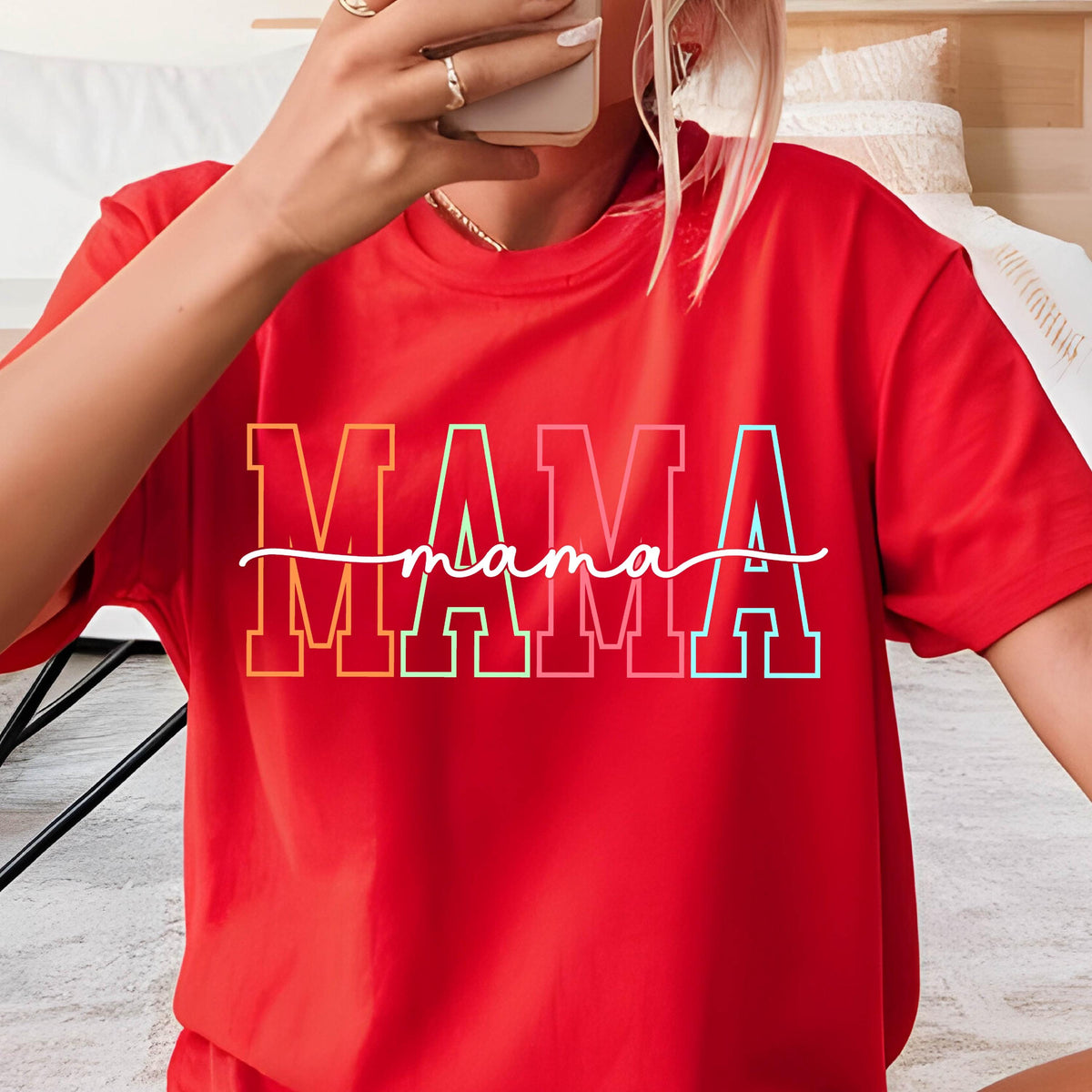 May include: Red short-sleeved t-shirt with a rainbow colored graphic that says "MAMA" with the word "mama" written in cursive underneath.