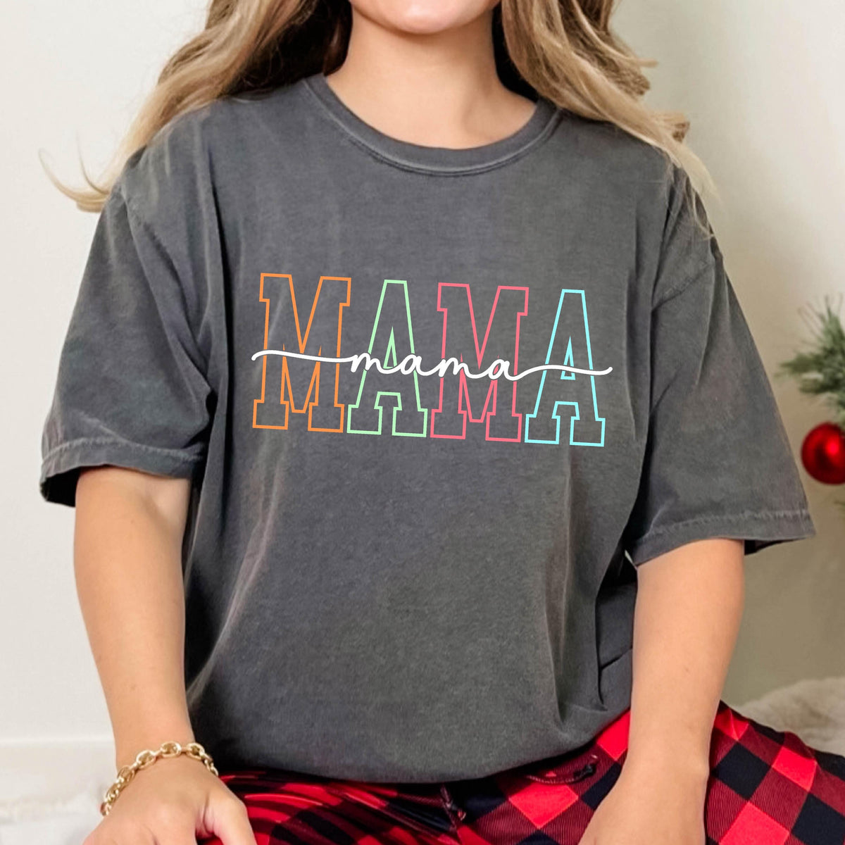 May include: A charcoal gray t-shirt with the word "MAMA" in rainbow colors and the word "mama" written in cursive underneath.