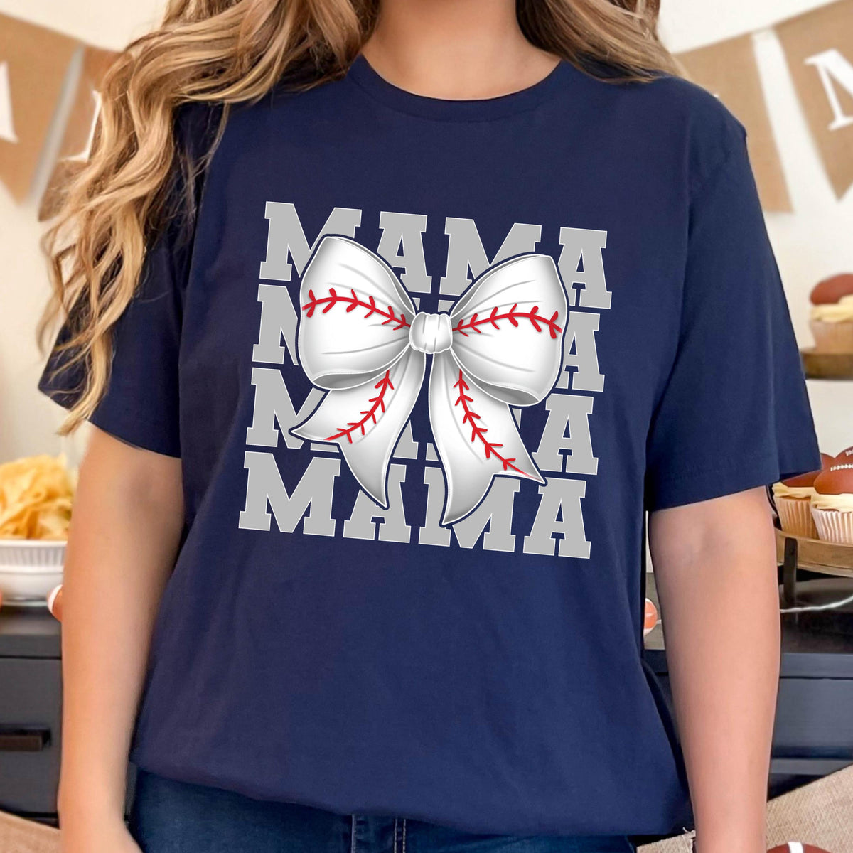 May include: Navy blue t-shirt with a white baseball-themed bow and the text "MAMA" repeated four times.
