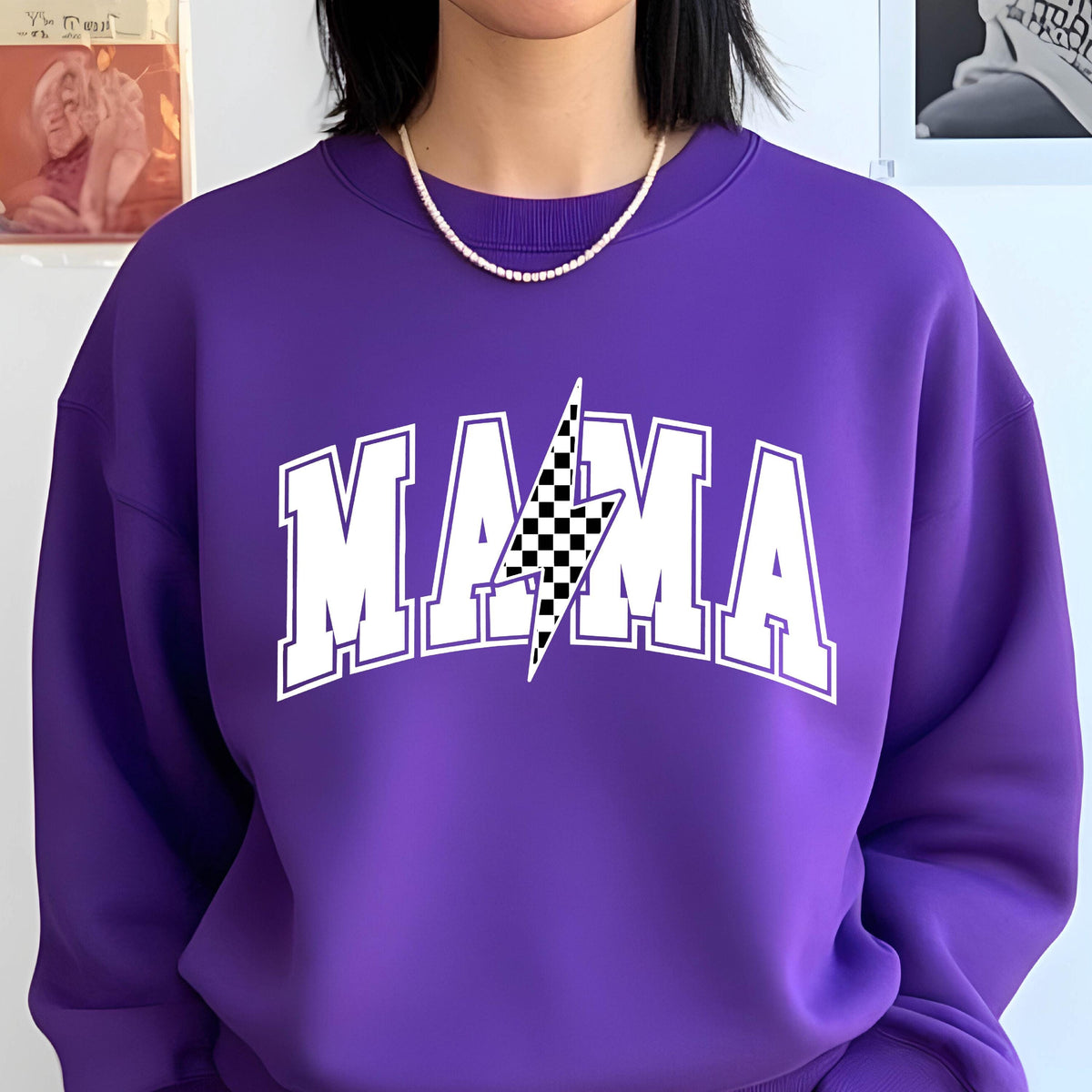 May include: Purple sweatshirt with a white graphic of the word "MAMA" with a checkered lightning bolt in the center.