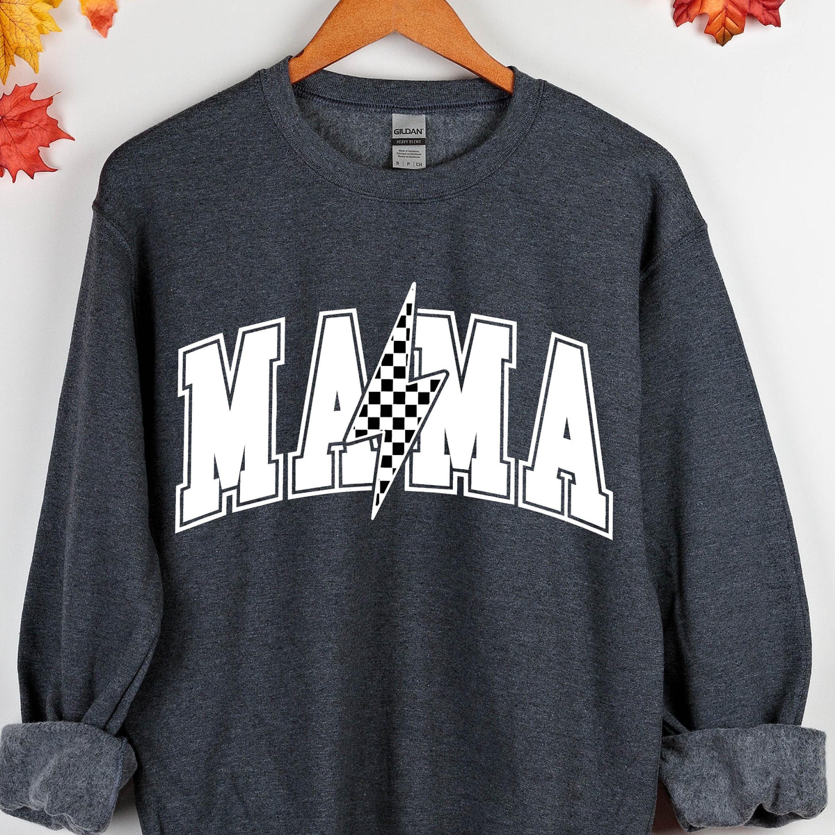 May include: A dark gray sweatshirt with the word "MAMA" in white letters with a black and white checkered lightning bolt in the center.