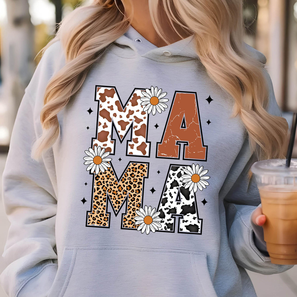 May include: Gray hooded sweatshirt with the word "MAMA" printed in large letters. The letters are decorated with cow print, leopard print, and floral designs.