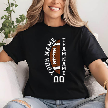 May include: A black short-sleeved t-shirt featuring a graphic of a brown football split vertically. The text "YOUR NAME" appears on the left, "TEAM NAME" on the right, and the number "00" is printed in white below the football graphic.
