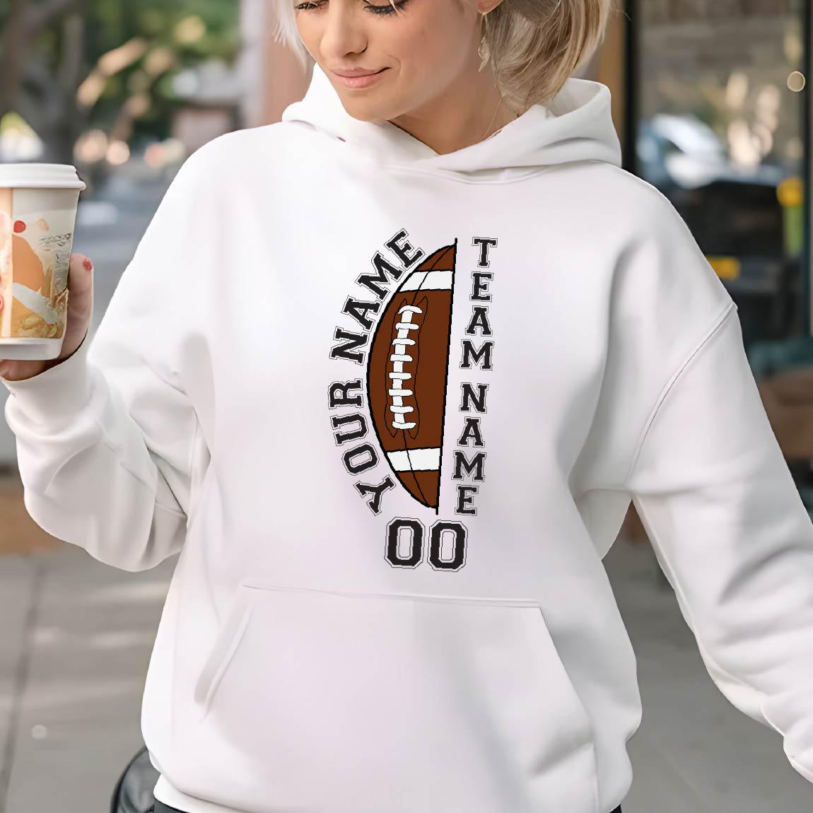 May include: White hoodie with a football graphic. The graphic includes a brown football with the text "YOUR NAME" and "TEAM NAME" in black, along with the number "00". The hoodie has a front pocket and a drawstring hood.