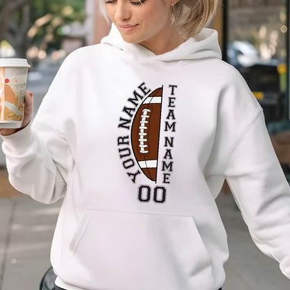 May include: White hoodie with a football graphic. The graphic includes a brown football with the text "YOUR NAME" and "TEAM NAME" in black, along with the number "00". The hoodie has a front pocket and a drawstring hood.