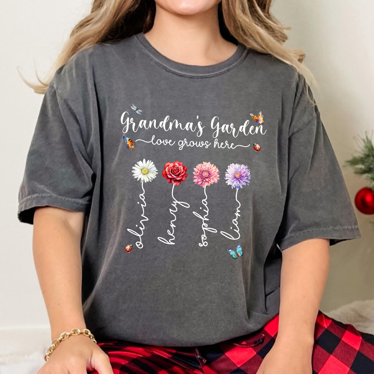 May include: A gray t-shirt with the text "Grandma's Garden - love grows here" and four flowers with names Olivia, Henry, Sophia, and Liam written on the stems.