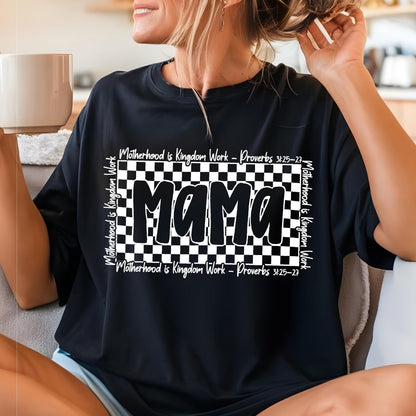 May include: Black t-shirt with a white checkered pattern and the word "Mama" in bold white letters. The text "Motherhood is Kingdom Work - Proverbs 3:25-27" is written in white on the top and bottom of the checkered pattern.