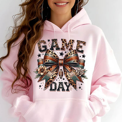 May include: Pink hoodie with a graphic print of a leopard print bow with a football and the text "GAME DAY" in black and gold letters.