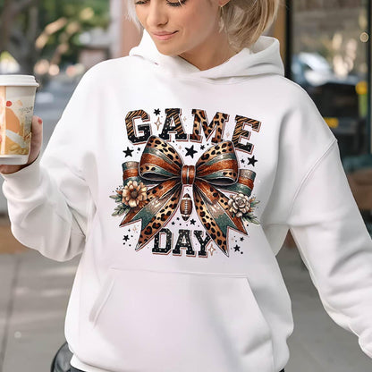 May include: White hoodie with a graphic print of a leopard print bow with a football and the text "GAME DAY" in black letters.
