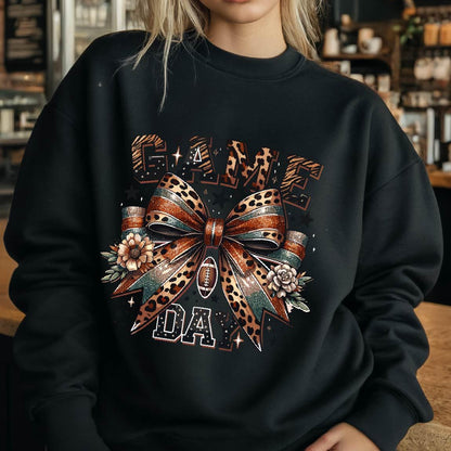 May include: Black sweatshirt with a graphic print of a leopard print bow with a football in the center. The text "GAME DAY" is printed below the bow.