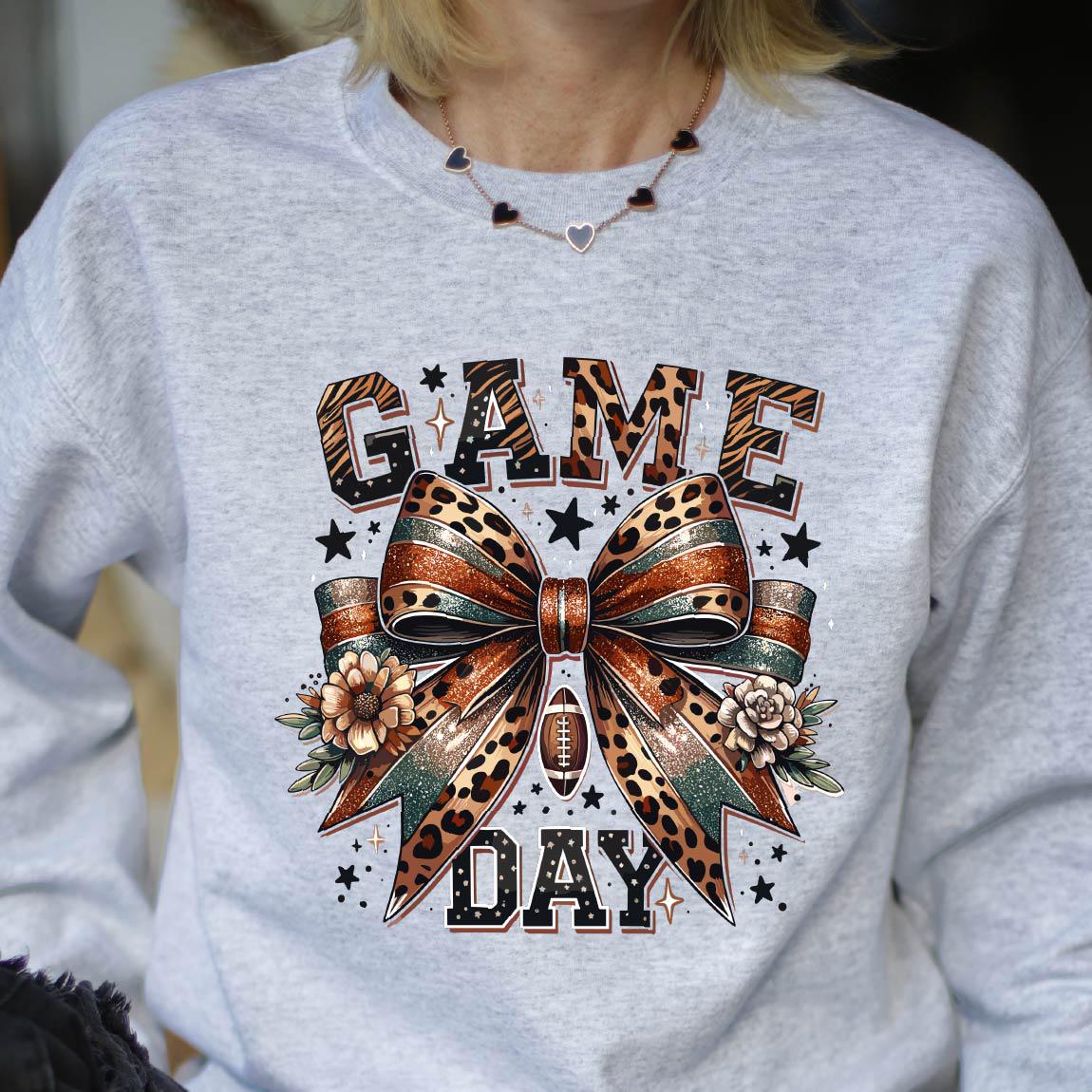 May include: A gray sweatshirt with a leopard print bow and the text "GAME DAY" printed on the front.