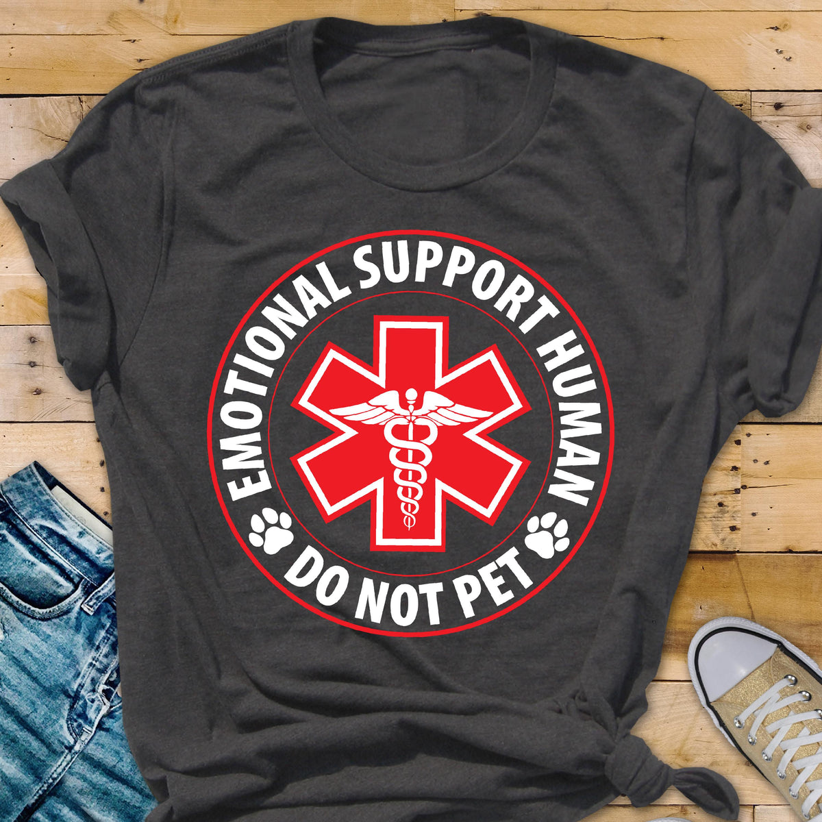 May include: Dark gray t-shirt featuring a red and white design. The design includes a red star of life symbol with a caduceus in the center, surrounded by the words "EMOTIONAL SUPPORT HUMAN" and "DO NOT PET".