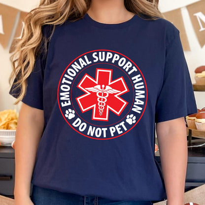 May include: Navy blue t-shirt with a red and white graphic. The graphic features a red star of life symbol with a caduceus in the center, surrounded by the words "EMOTIONAL SUPPORT HUMAN" and "DO NOT PET".