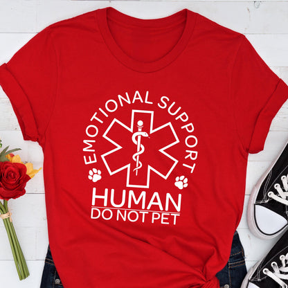 May include: A bright red t-shirt featuring a white graphic of a six-pointed star of life symbol with a snake and staff. The text reads EMOTIONAL SUPPORT HUMAN DO NOT PET, accompanied by two small paw print icons on either side of the central emblem.