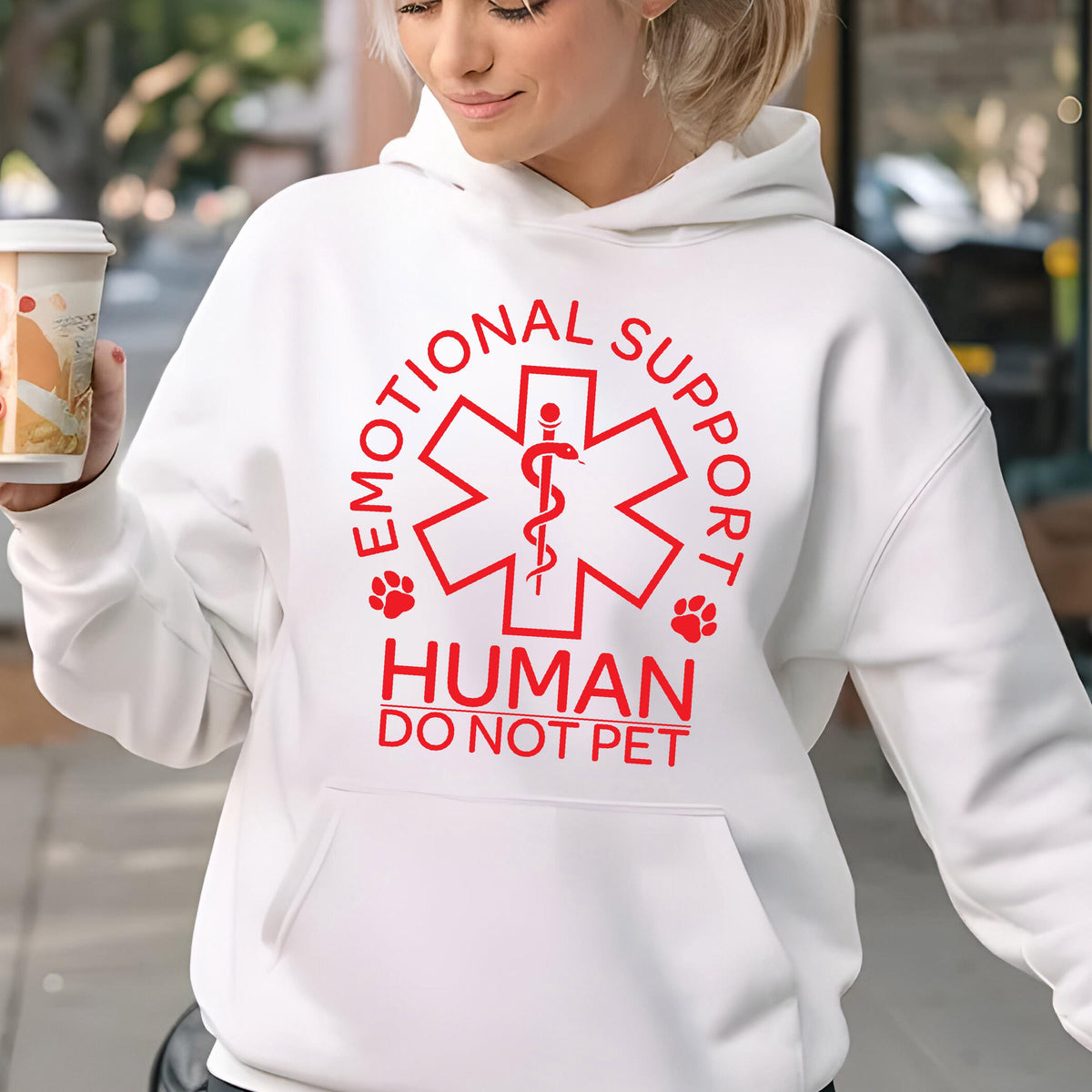May include: White hoodie with a red graphic of a medical symbol, the words "Emotional Support Human Do Not Pet" and paw prints.