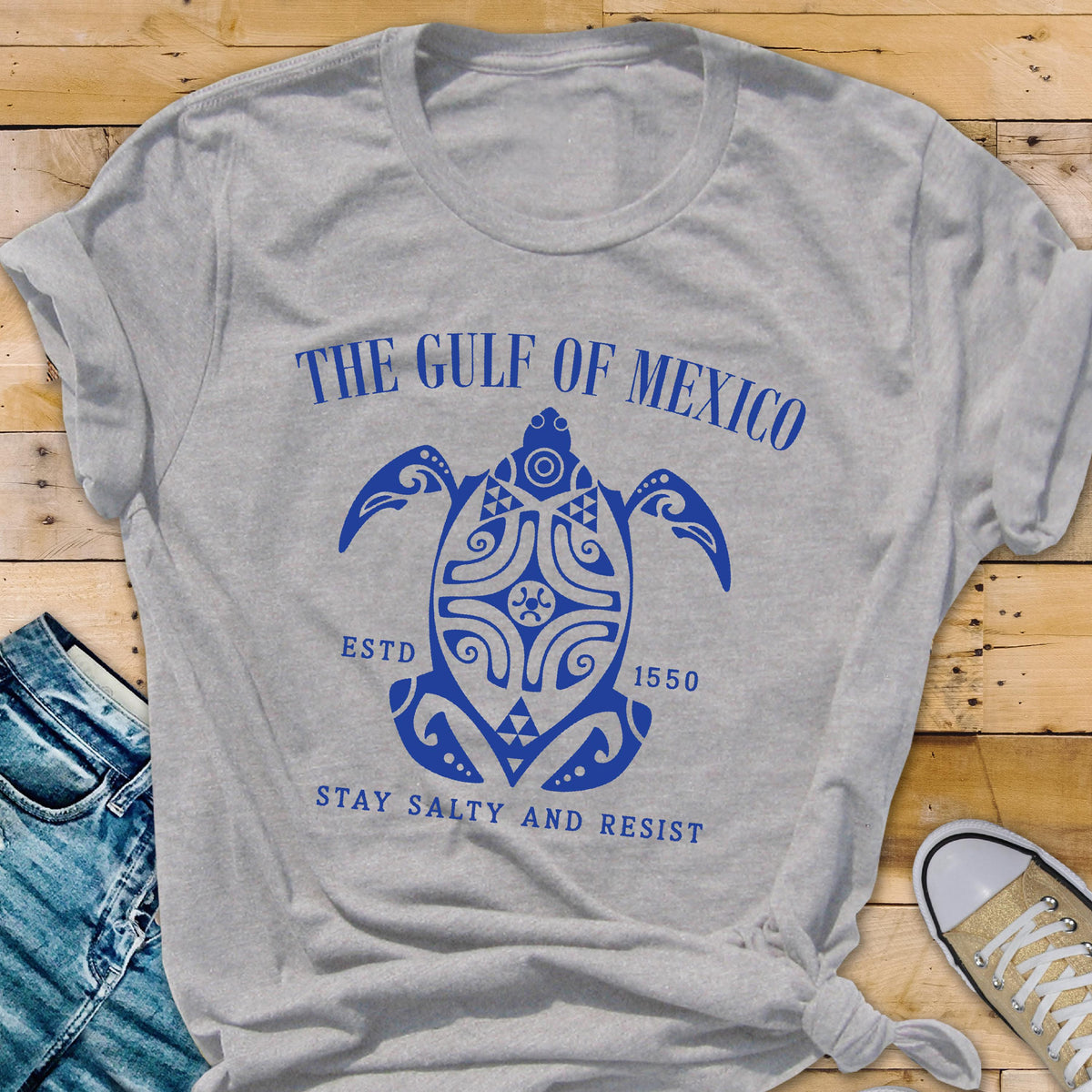 May include: Gray t-shirt with a blue graphic of a stylized turtle with the text "The Gulf of Mexico EstD 1550 Stay Salty and Resist".