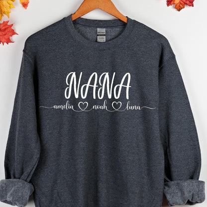 May include: A dark gray sweatshirt with the word "NANA" in white lettering and three names, "amelia", "noah", and "luna", written below in smaller white lettering. Each name is followed by a small white heart.