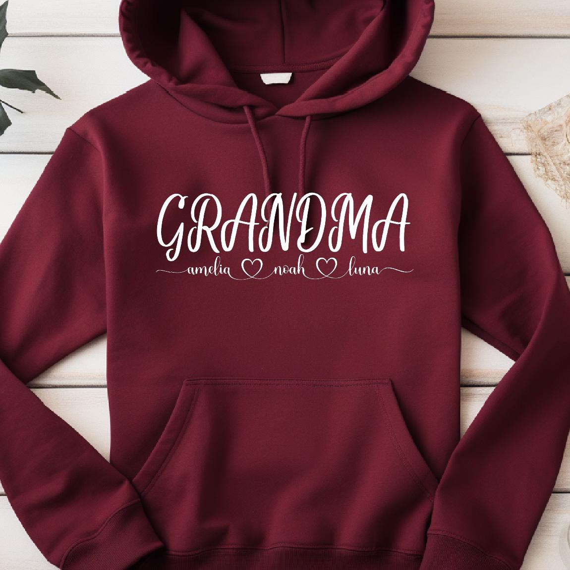 May include: Burgundy hooded sweatshirt with the text "GRANDMA" in white cursive lettering. Below the text are the names "amelia", "noah", and "luna" with a heart symbol between each name.