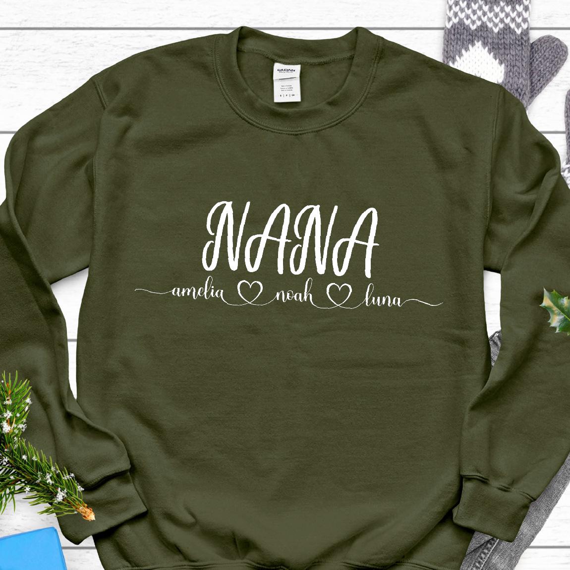 May include: A green sweatshirt with the word "NANA" in white lettering. Below the word "NANA" are the names "amelia", "noah", and "luna" with a heart symbol between each name.
