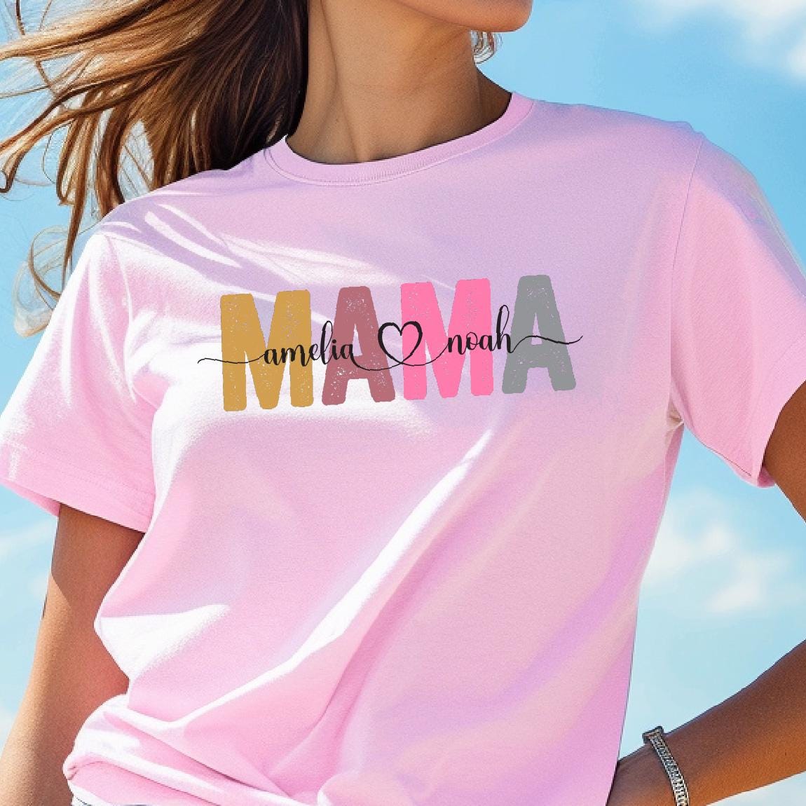 May include: Pink t-shirt with the word "MAMA" in colorful letters, with the names "Amelia" and "Noah" written in smaller letters below.