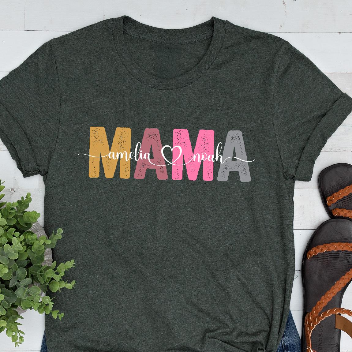May include: A dark green t-shirt with the word "MAMA" in colorful letters. The letters are in shades of yellow, pink, and gray. The words "amelia" and "noah" are written in smaller letters below the word "MAMA" with a heart symbol between them.