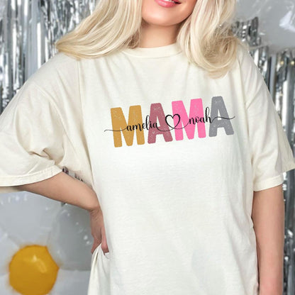 May include: A white t-shirt with the word "MAMA" in colorful letters, with the names "Amelia" and "Noah" written in black script on either side of a pink heart.
