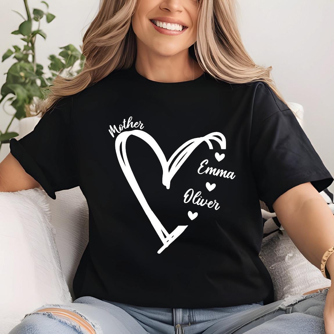 May include: Black t-shirt with a white heart design and the words "Mother", "Emma", and "Oliver" inside the heart.